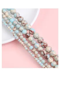 Gros plan de perles rondes en pierre synthétique marbrée bleue et beige, tailles
