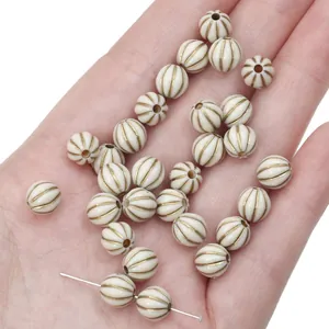 Detail view of French vintage acrylic beads with gold painted grooves for DIY