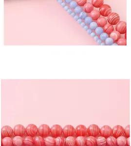 Détail de perles rondes en pierre synthétique rayée rose et violette pour bijoux DIY.