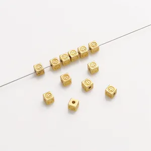 Detailed macro view of 14K gold-filled smiley face square spacer beads for DIY jewelry