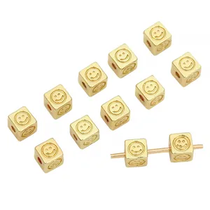 Detail macro view of 14K gold filled square smiley face spacer beads for DIY jewelry making