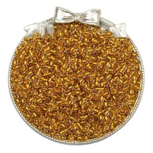 Detail view of high-quality golden silver-lined glass seed beads in a bow tray