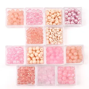 Assorted pink glass and crystal beads in transparent boxes for DIY jewelry making