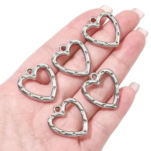Macro-opname van vijf zilverkleurige hartvormige CCB-hangers voor DIY-sieraden maken.