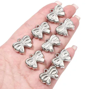 Zilveren strikbedels in de hand gehouden voor DIY maken van kettingen en armbanden