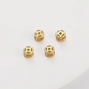 Macro detail of 14K gold filled hollow spacer beads with traditional Chinese coin motif