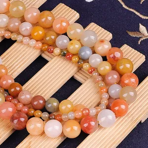 Macro view of multi-sized natural red gold silk jade round beads for DIY jewelry making
