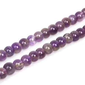 Close-up macro detail of natural purple amethyst round beads showing unique crystal texture