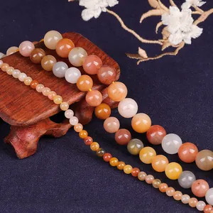High-quality macro detail of natural red gold silk jade round beads for jewelry making