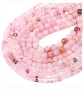 Dettaglio macro di perline rotonde in giada sintetica rosa per creazione di gioielli fai-da-te