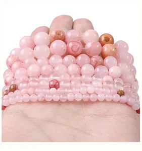 Primo piano di perline tonde in giada persiana sintetica rosa in varie dimensioni