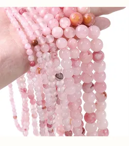 Primo piano di perle rotonde in giada persiana sintetica rosa per accessori gioielli fai-da-te