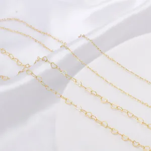 Detailed close-up view of multiple sizes of 14K gold-filled heart shaped link chains