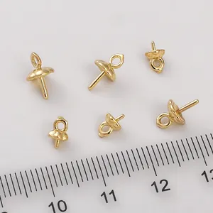 Detalle de capuchones para perlas bañados en oro de 14K con pasadores junto a regla