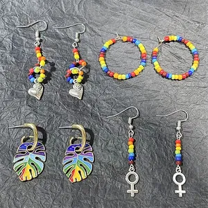 Handmade rainbow glass seed bead earrings set with silver heart and enamel leaf charms