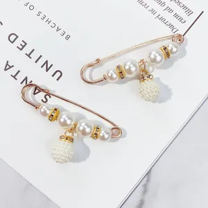 Detailansicht eleganter Perlen-Sicherheitsnadel-Broschen mit Strass-Anhängern auf Magazin