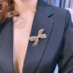 Detaillierte Nahaufnahme einer eleganten, kristallbesetzten goldenen Schleifenbrosche