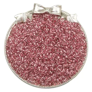 Detailed macro shot of pink silver-lined glass seed beads for DIY jewelry making.