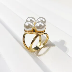 Close-up of elegant gold-plated scarf buckle with four large white pearls