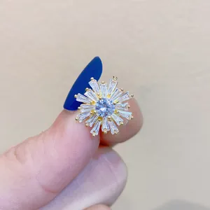 Nahaufnahme einer luxuriösen Schneeflockenbrosche mit klaren Zirkoniasteinen auf Gold.