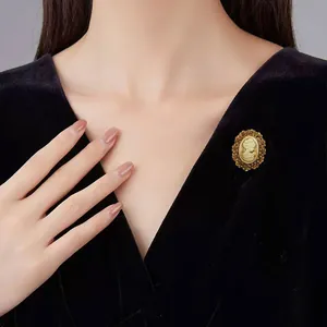 Vue détaillée d'une broche camée dorée vintage épinglée sur une robe en velours noir