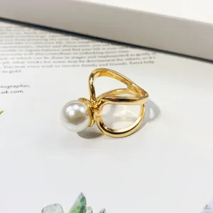 Detailed macro view of an elegant gold-plated scarf buckle featuring a large white pearl