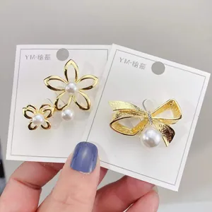 Elegante Broschen in Blumen- und Schleifenform aus Goldlegierung mit weißen Perlen
