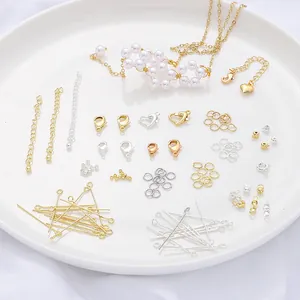 Assorted gold and silver DIY jewelry findings, clasps, and pins on a white ceramic plate