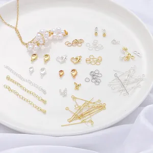 Detailed macro view of assorted gold and silver jewelry findings on a white ceramic plate