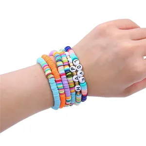 Gros plan de bracelets en perles de polymère colorées avec perles de lettres 'LOVE' et 'HAPPY'