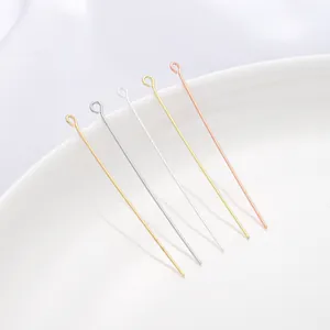 Close-up view of five metallic jewelry eye pins in gold, silver, and rose gold finishes.