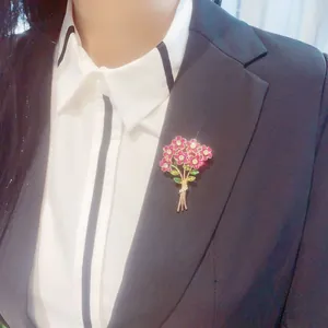 Close-up of a sparkling pink crystal flower bouquet brooch pinned to a black blazer.