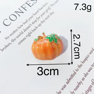 Vista dettagliata di una spilla a zucca di Halloween arancione da 3 cm per 2,7 cm