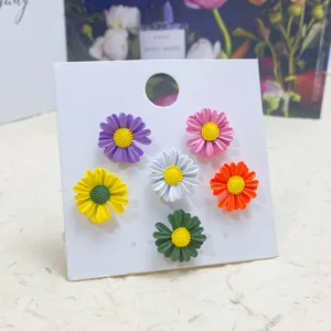 Detailed view of six colorful daisy floral collar pins on a white display card