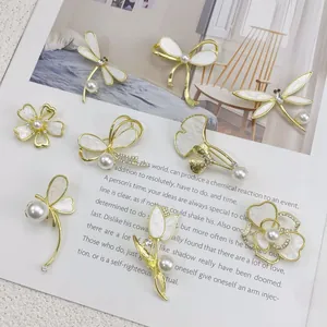 Kollektion eleganter Muschelbroschen mit Perlen- und Strassdetails in Gold-Finish