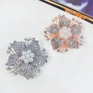 Detaillierte Makroansicht eleganter Kristallblumen-Brosche mit weißen Perlen in Silber und Roségold