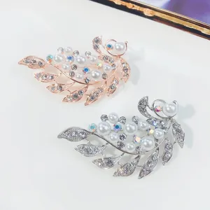 Detailansicht von Blumenbroschen in Silber und Roségold mit Kristallen und Perlen