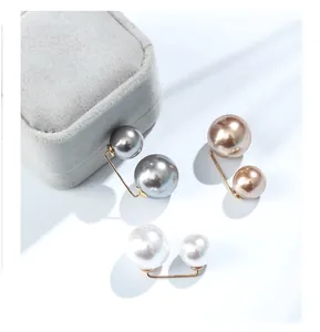 Detail view of double pearl waist reduction pins in silver, bronze, and white for clothing.