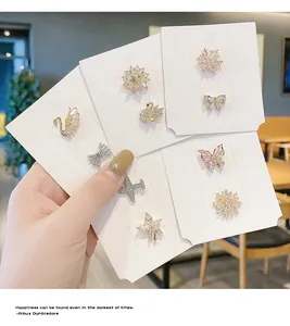 Nahaufnahme von eleganten Kristall-Mini-Broschen in Designs wie Schwan und Schmetterling