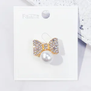 Detaillierte Nahaufnahme einer eleganten Strass-Schleifenbrosche mit einer großen weißen Perle