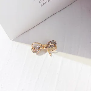 Elegante mini spilla a forma di fiocco dorato con strass trasparenti per abiti da donna