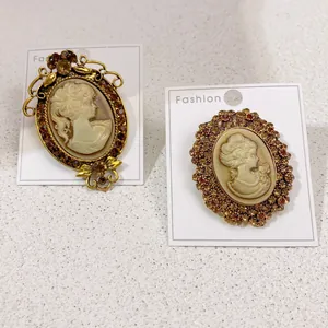 Gros plan sur deux broches camée vintage avec un design élégant de tête de femme et cristaux