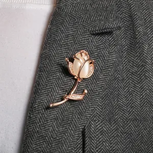 Elegant rose gold tulip brooch with opal stone pinned on a grey herringbone suit jacket