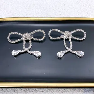 Detailed view of elegant silver bowknot brooch with shimmering rhinestones and tassels