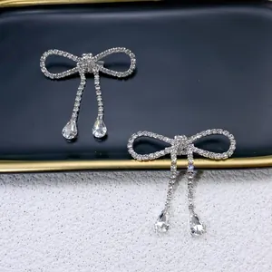 Close-up detail of elegant silver bowknot brooches with sparkling rhinestone tassels