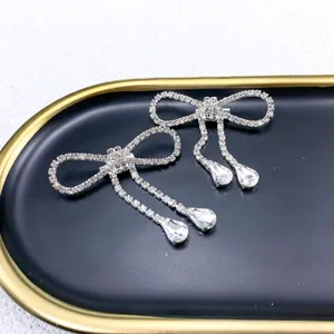 Close-up detail of an elegant silver bow brooch with sparkling rhinestones and tassels