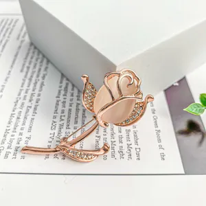 Close-up of elegant rose gold rose brooch with pink gemstone and crystal accents