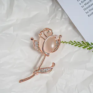 Close-up of elegant rose gold tulip brooch with pink cat's eye stone and rhinestones