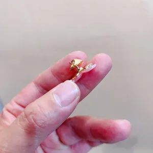 Seitenansicht einer kleinen goldenen Sicherheitsbrosche für Damenbekleidung mit V-Ausschnitt