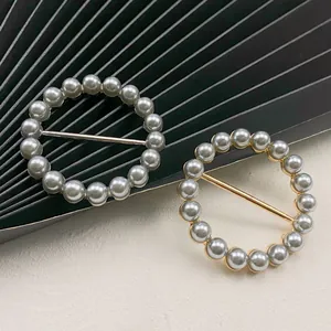 Nahaufnahme von eleganten runden Perlen-Schalschnallen in Gold- und Silberoptik